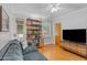 Cozy living room with hardwood floors, a gray sofa, shelving unit and a ceiling fan at 502 W Windsor Ave, Phoenix, AZ 85003
