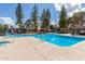Community pool featuring blue water, lounge chairs, and surrounding green trees at 5136 E Evergreen St # 1142, Mesa, AZ 85205