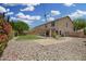 A spacious backyard features a grassy lawn, rock landscaping, and views of a well-maintained two-story home with a covered patio at 5440 W Apollo Rd, Laveen, AZ 85339