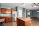 Open kitchen with wood cabinets, tile flooring, and stainless steel refrigerator at 5440 W Apollo Rd, Laveen, AZ 85339