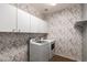 Charming laundry room with washer, dryer, upper cabinets and decorative wallpaper at 5440 W Apollo Rd, Laveen, AZ 85339