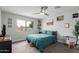 Bedroom features a ceiling fan, large window with neighborhood views, and carpeted floor at 5702 S Beck Ave, Tempe, AZ 85283