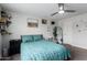 Bedroom with teal comforter, carpeted floor, ceiling fan and curated decor at 5702 S Beck Ave, Tempe, AZ 85283