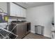 Functional laundry room with appliances, storage cabinets, and a water heater at 5702 S Beck Ave, Tempe, AZ 85283