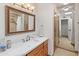 Updated bathroom featuring a marble countertop, wood cabinets, and a walk-in shower at 5711 E Corrine Dr, Scottsdale, AZ 85254