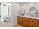 Well-lit bathroom with double sinks, modern fixtures, a walk-in shower, and ample storage for convenience at 5711 E Corrine Dr, Scottsdale, AZ 85254