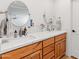 Contemporary bathroom with a double vanity, granite countertop, modern round mirrors, and stylish fixtures at 5711 E Corrine Dr, Scottsdale, AZ 85254