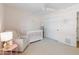 Bright bedroom with a ceiling fan, chair, crib, and white sliding closet doors at 5711 E Corrine Dr, Scottsdale, AZ 85254