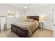 Comfortable bedroom with a dark wood bed frame, side tables with lamps, and a ceiling fan at 5711 E Corrine Dr, Scottsdale, AZ 85254