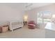Bright bedroom with a ceiling fan, a crib, a chair, and a window with white shutters at 5711 E Corrine Dr, Scottsdale, AZ 85254