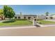 Lovely single-story home with a manicured lawn, mature trees, and a tidy walkway leading to the entrance at 5711 E Corrine Dr, Scottsdale, AZ 85254