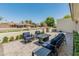 Inviting patio with modern outdoor seating, a fire pit, and manicured landscaping and decorative white wall in the background at 5711 E Corrine Dr, Scottsdale, AZ 85254