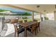 Covered patio with wood table and chairs, an outdoor kitchen with grill, and lounge furniture for relaxing at 5711 E Corrine Dr, Scottsdale, AZ 85254