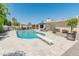 Backyard view of a refreshing pool with diving board, tiled patio, lounge chairs and well-kept landscaping at 5711 E Corrine Dr, Scottsdale, AZ 85254