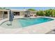 A spacious swimming pool with beach style entry and lounge chairs, surrounded by a paved patio and manicured landscaping at 5711 E Corrine Dr, Scottsdale, AZ 85254