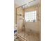 Tiled shower with a glass enclosure, built-in bench, and natural light streaming through the glass block window at 5711 E Corrine Dr, Scottsdale, AZ 85254