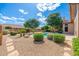 A beautifully landscaped backyard with a refreshing pool, complemented by lush greenery and stone accents at 6135 E Campo Bello Dr, Scottsdale, AZ 85254