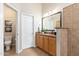 Well-lit bathroom with granite countertop, white cabinets, and a toilet in a separate room at 6135 E Campo Bello Dr, Scottsdale, AZ 85254
