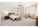 Spacious bedroom with neutral tones, plantation shutters, seating area, and ceiling fan at 6135 E Campo Bello Dr, Scottsdale, AZ 85254