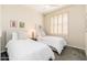 Bright bedroom featuring two twin beds, comfortable bedding, and a window with white shutters at 6135 E Campo Bello Dr, Scottsdale, AZ 85254