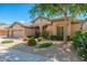 Well-manicured front yard with lush desert landscaping and a mature tree for shade at 6135 E Campo Bello Dr, Scottsdale, AZ 85254