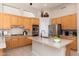 Well-lit kitchen features wooden cabinets, stainless steel appliances, an island, and granite countertops at 6135 E Campo Bello Dr, Scottsdale, AZ 85254