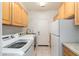 Convenient laundry room features a modern washer and dryer, ample cabinets, and a door to the outside at 6135 E Campo Bello Dr, Scottsdale, AZ 85254