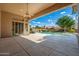 Covered patio with ceiling fan overlooking the sparkling pool and lush backyard at 6135 E Campo Bello Dr, Scottsdale, AZ 85254