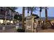 Evening street view with palm trees, Kierland directory sign, shops, and lighted storefronts at 6135 E Campo Bello Dr, Scottsdale, AZ 85254