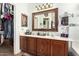 Bathroom vanity features dual sinks, a decorative mirror, and a charming, rustic aesthetic at 630 E Racine Pl, Casa Grande, AZ 85122