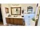 Bathroom featuring double sinks, wooden cabinets, and white countertops, accented by unique decorations at 630 E Racine Pl, Casa Grande, AZ 85122