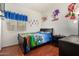 Bedroom with playful decor, a mounted TV, and wood floors, creating a fun and comfortable space at 630 E Racine Pl, Casa Grande, AZ 85122