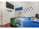 Bedroom with playful decor, a mounted TV, and wood floors, creating a fun and comfortable space at 630 E Racine Pl, Casa Grande, AZ 85122
