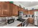 Close-up of modern kitchen with granite countertops, stainless steel appliances, and dark wood cabinetry at 630 E Racine Pl, Casa Grande, AZ 85122