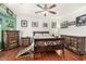 Open primary bedroom with wood floors, ceiling fan, rustic furniture, and decorative artwork at 630 E Racine Pl, Casa Grande, AZ 85122