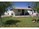 View of the backyard of this home featuring well-maintained grass and a covered patio area at 6725 W Cypress St, Phoenix, AZ 85035