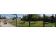 Large backyard features a small playset and mature trees with a covered patio at 6725 W Cypress St, Phoenix, AZ 85035