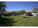 Large private backyard with a playset, mature trees and grassy lawn at 6725 W Cypress St, Phoenix, AZ 85035