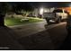 Inviting driveway with pavers, lush artificial turf, mature trees, and ample parking space at 6725 W Cypress St, Phoenix, AZ 85035