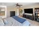 Spacious bedroom with television, ceiling fan, and open doorway to bathroom at 7469 E Timberlane Ct, Scottsdale, AZ 85258
