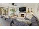 Cozy living room featuring a modern fireplace, TV, comfortable seating, and an abundance of natural light at 7469 E Timberlane Ct, Scottsdale, AZ 85258
