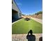 Backyard with manicured turf, a stone border, and an outdoor dining set at 8024 W State Ave, Glendale, AZ 85303