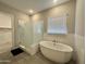 Elegant bathroom with a soaking tub, glass-enclosed shower, and neutral finishes at 8024 W State Ave, Glendale, AZ 85303
