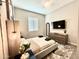 Bright bedroom featuring a stylish upholstered bed frame, ceiling fan, and dresser with mounted TV at 8024 W State Ave, Glendale, AZ 85303