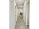 Well-lit hallway with wood-look tile flooring and white doors leads to various rooms at 8024 W State Ave, Glendale, AZ 85303