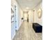 Well-lit hallway features wood-style tile flooring, leading to various rooms with modern decorations at 8024 W State Ave, Glendale, AZ 85303
