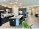 Spacious kitchen with granite island, stainless steel appliances, dark cabinets, and tiled floor at 8024 W State Ave, Glendale, AZ 85303