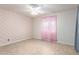 Spacious bedroom with patterned wallpaper, ceiling fan, and light wood-look flooring at 9227 N 36Th Dr, Phoenix, AZ 85051