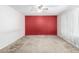 Empty bedroom showcasing red accent wall, ceiling fan, and carpet at 9227 N 36Th Dr, Phoenix, AZ 85051