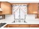 Close up on a kitchen sink with floral curtains and white countertops at 9227 N 36Th Dr, Phoenix, AZ 85051